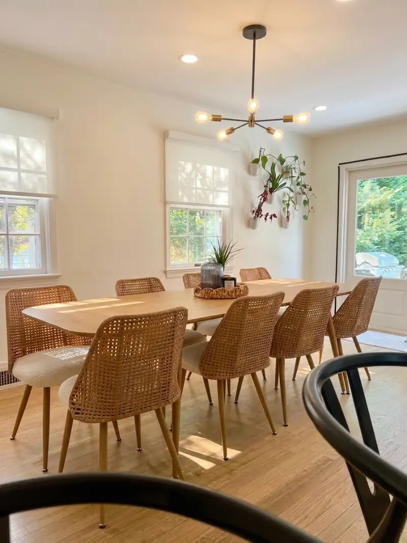 Dining room with rattan chairs under a branching chandelier